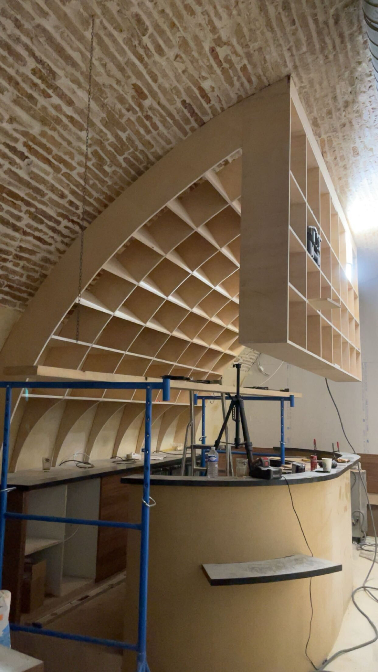 Agencement sur mesure : casiers bois cintrés sous voûte en pierre