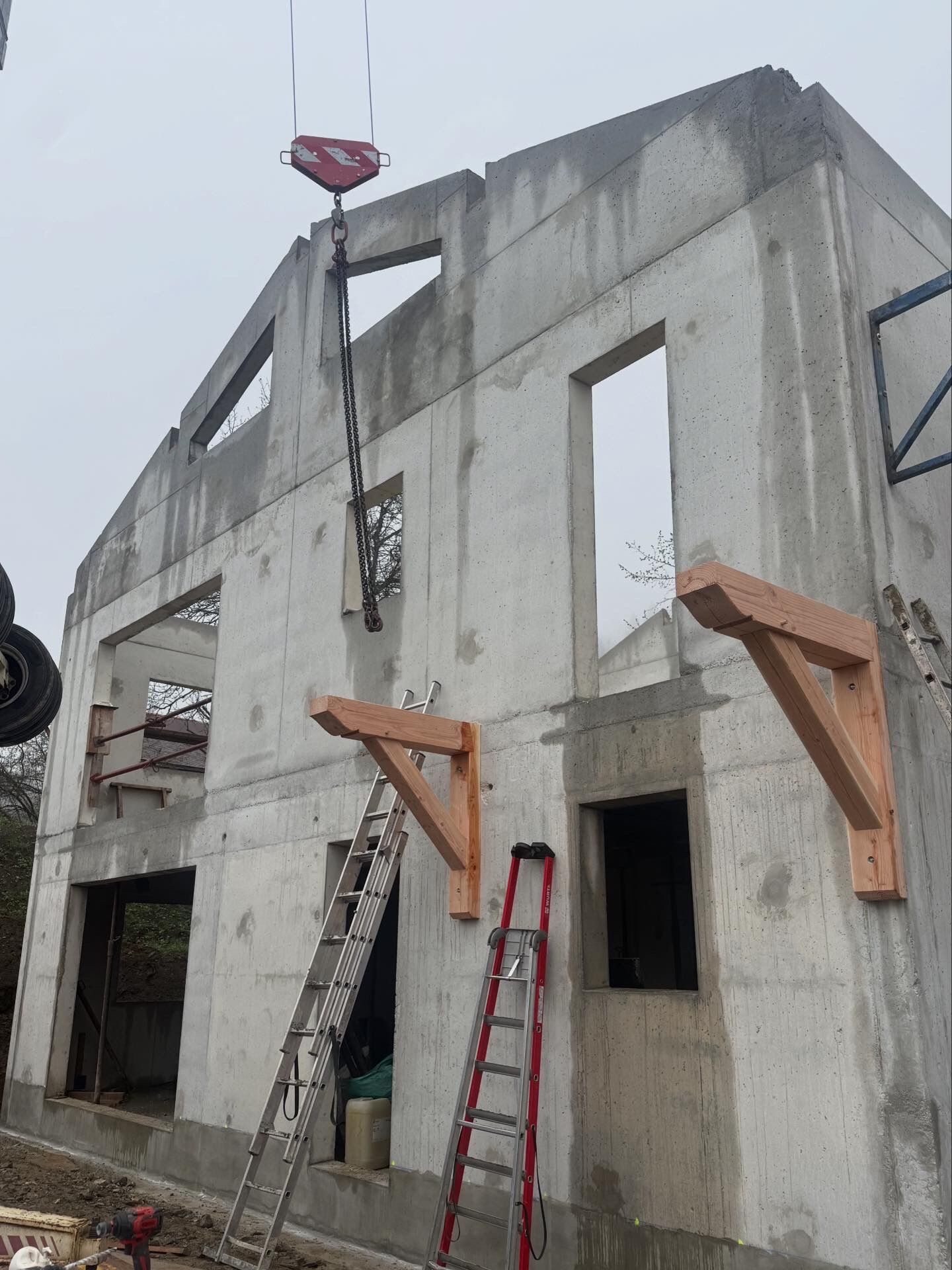 Avant : consoles bois fixées sur les murs béton, avant la pose du balcon et de l'auvent